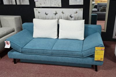 Querschläfer mit Bettkasten und Hubbeschlag für leichtes Vorziehen und öffnen. Federkern im Sitz und im Rücken. Stoff petrol mit weiß gemusterten Kissen. Seiten beidseitig verstellbar als Kopfstütze oder Armteil. Maß: B 200 cm H 85 cm T 90 cm. Liegefläche 140 x 200 cm.