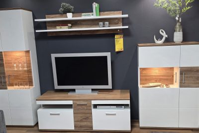 Wohnwand Front weiß Hochglanz mit Absetzung Sterling Oak, Korpus weiß matt Melamin Nachbildung. Front und Seitenverglasung Parsol grau, Schubkastenführungen gedämpft. Bestehend aus Vitrine, TV-Element, Highboard und Wandpaneel. B ca. 330 cm x H 199 cm x T 50 cm. Inklusive Beleuchtung. Ohne Deko