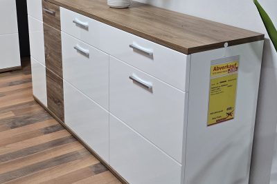 Sideboard Front weiß Hochglanz mit Absetzung Sterling Oak, Korpus weiß matt Melamin Nachbildung. 3 Türen, 1 Schubkasten gedämpft. B 180 cm x H 135 cm x T 37 cm. Ohne Deko